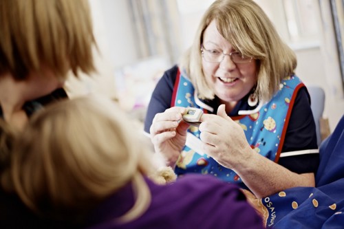 A friendly nurse in the Paediatrics department at Spencer Hospitals shows a child how to use a pulse oximeter.