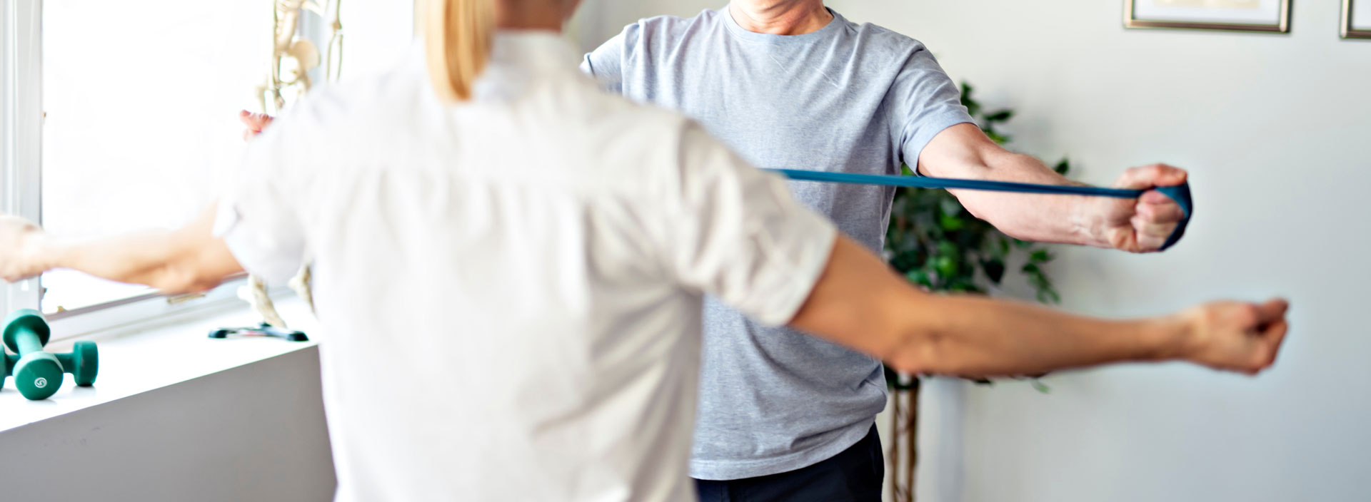 A private physiotherapist guides the patient through a rehabilitation exercise.